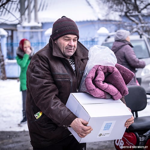 20230217_Man_Carrying_Box_and_Blanket_©Oro_Whitley_Ukraine_Response_Food_Boxes_and_Blankets_Distribution copy