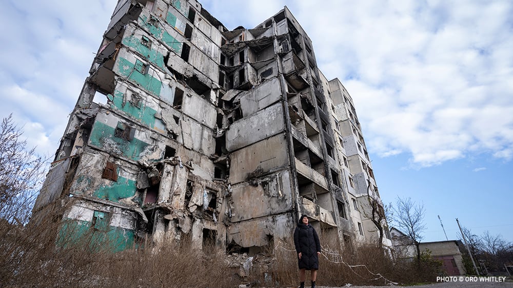 20231121_Borodianka_0081_guide_in_front_of_destroyed_building_©_Oro_Whitley_GGC_Ukraine_Relief