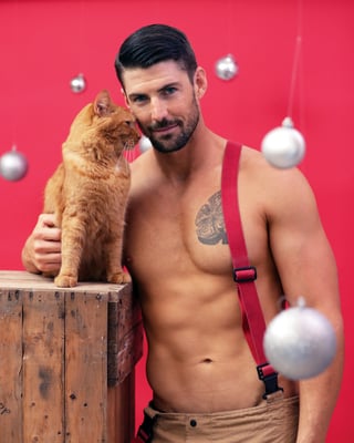 Brendan and feline friend post for the Australian Firefighters Cats Calendar 2022