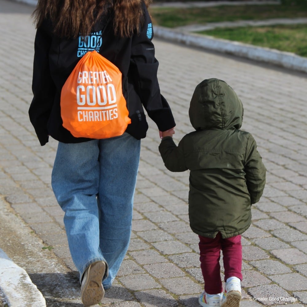 Greater Good Charities and Rufugee Child Walking with an Emergency Pack