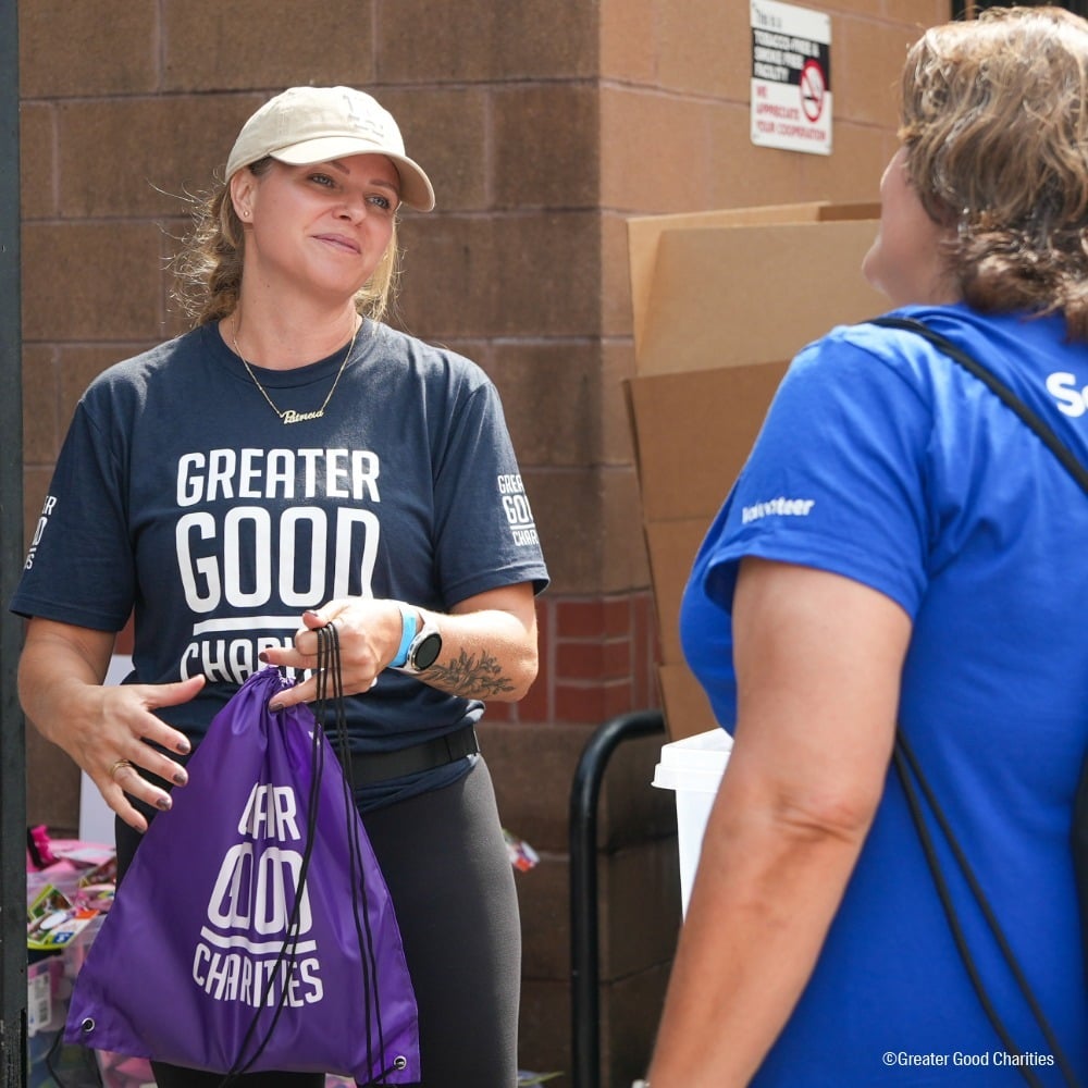 Greater Good Charities Volunteer Handing Out Emergency Packs